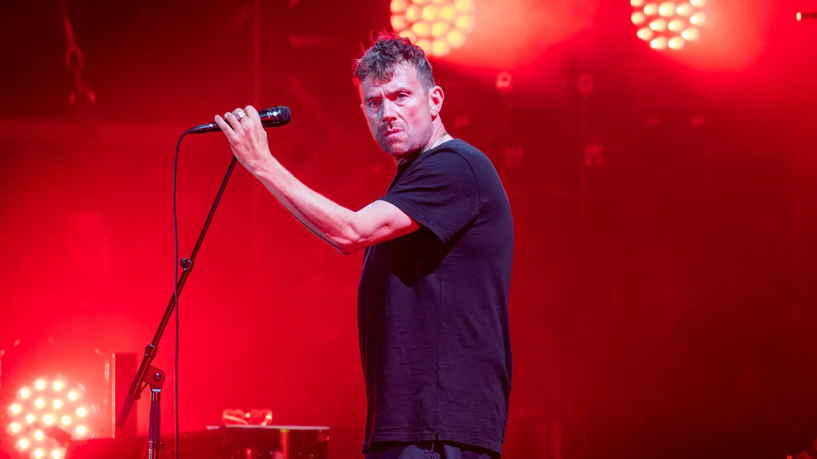 A headliner bathed in red light on the All Points East main stage at night