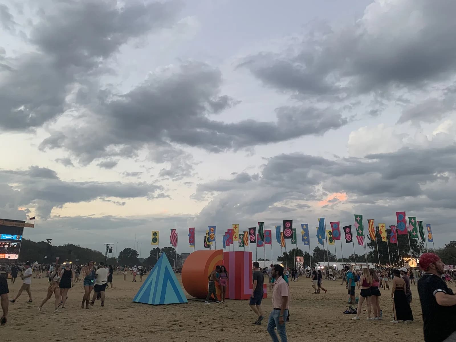 The ACL letters art installation and festival flags on the Zilker Park field at dusk