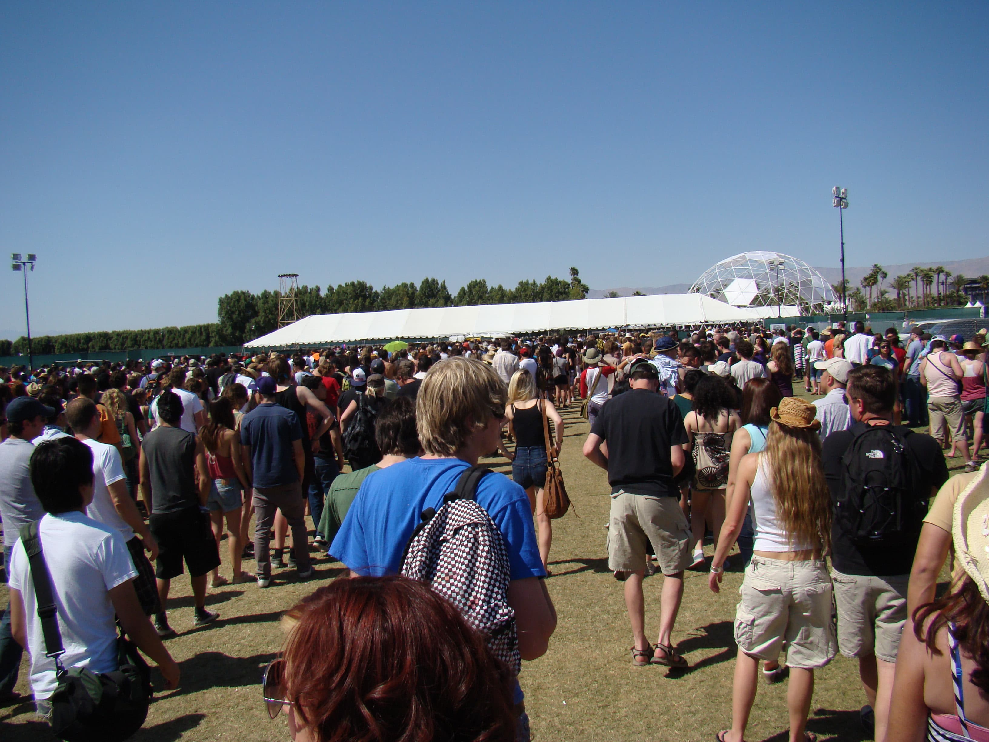 A daytime Coachella crowd gathered near a large dome installation