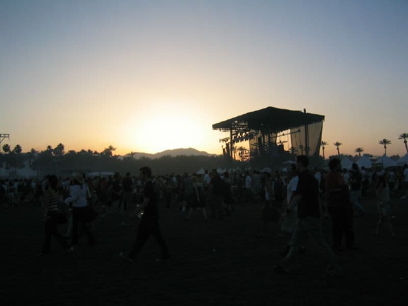 Coachella main stage at sunset with a crowd in front of the stage