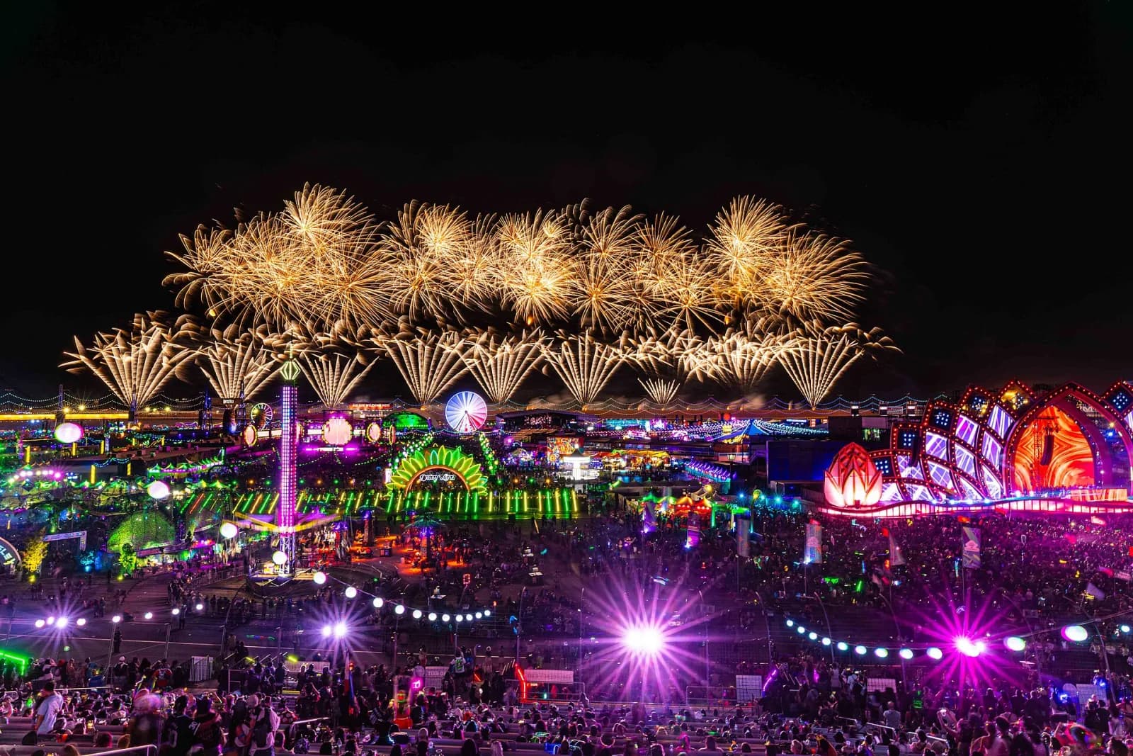 Golden fireworks over the full neon expanse of EDC Las Vegas at the Speedway