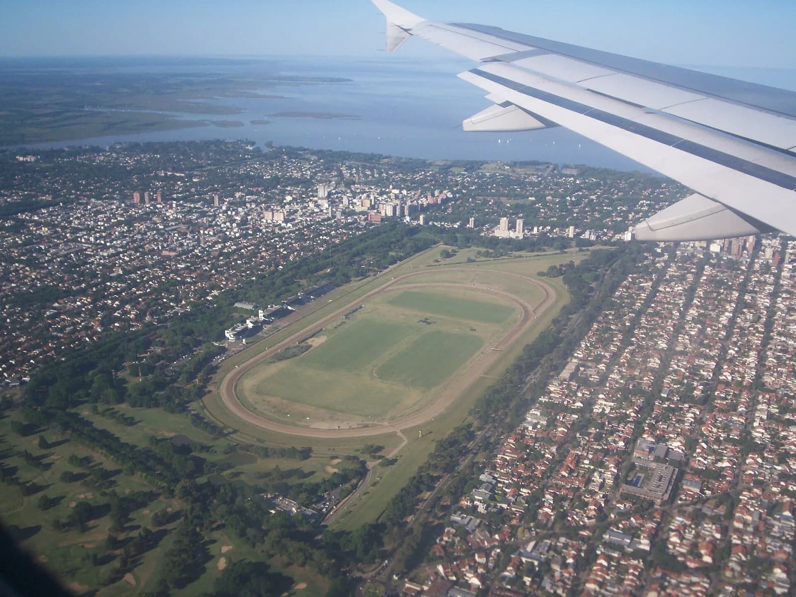 Aerial view of the Hipódromo de San Isidro racecourse surrounded by Buenos Aires suburbs with the Río de la Plata behind