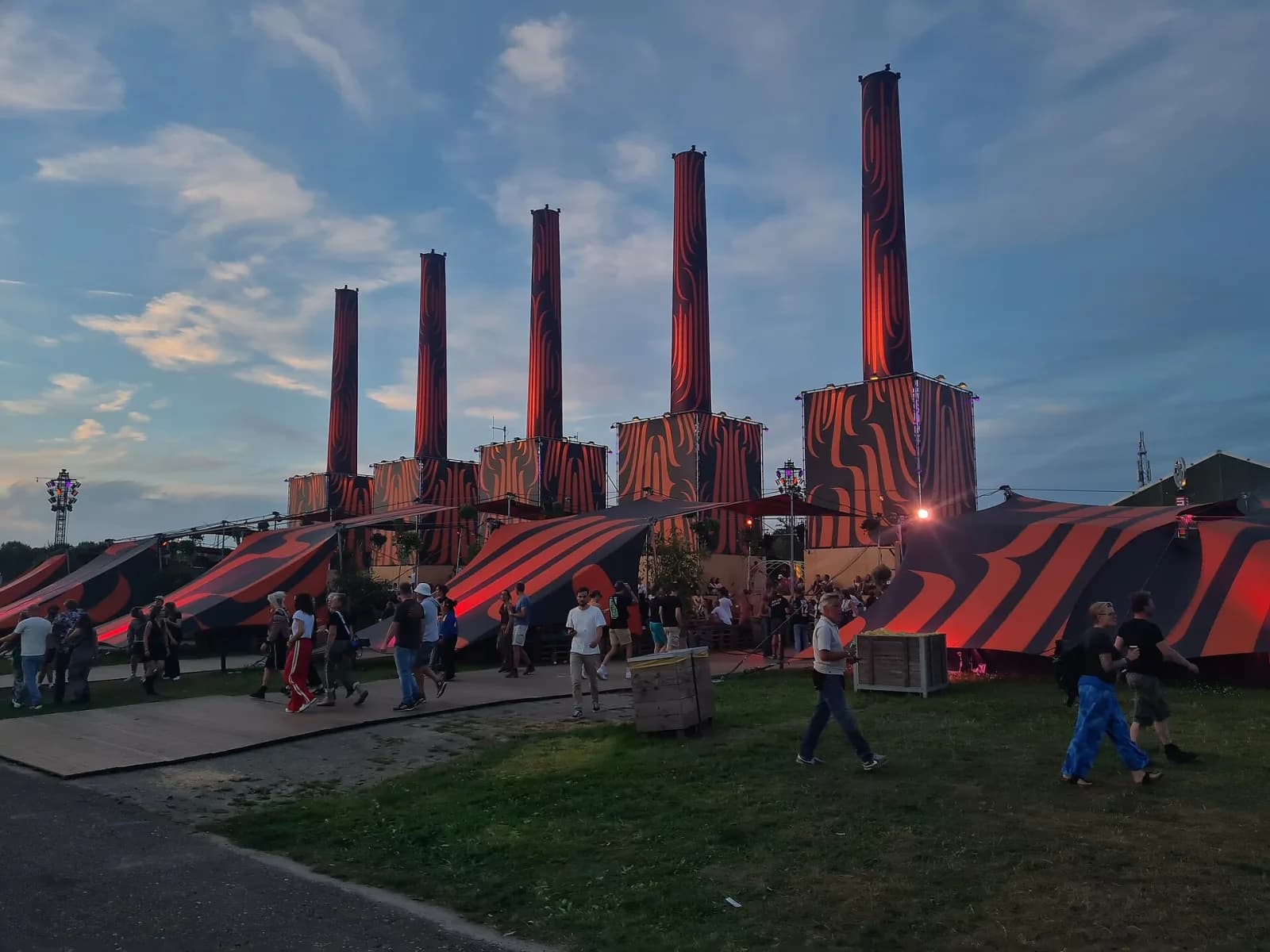 Red-and-black patterned chimney towers glowing at dusk at Lowlands 2024