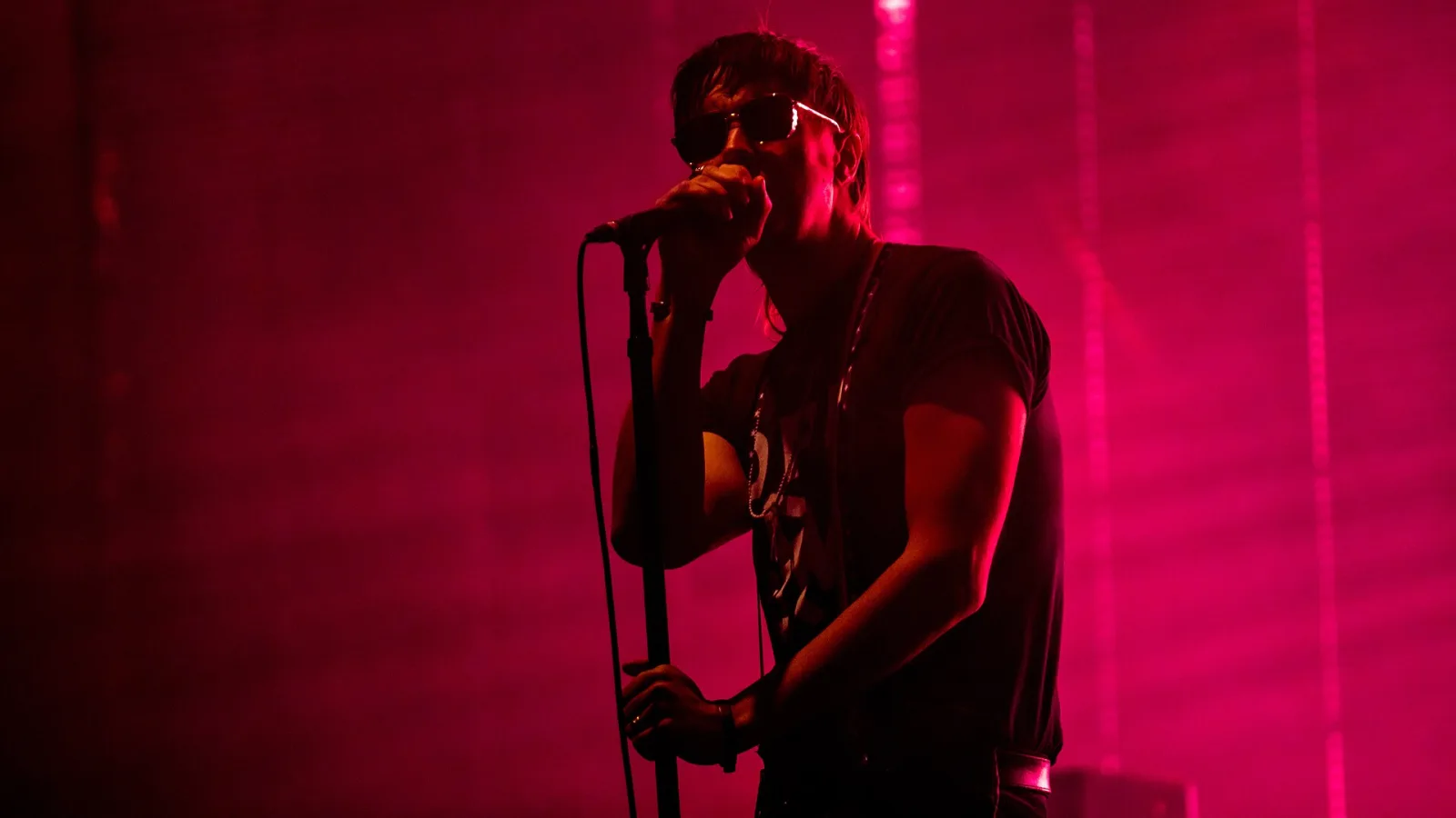 Julian Casablancas of The Strokes singing in deep magenta light at Open'er 2019