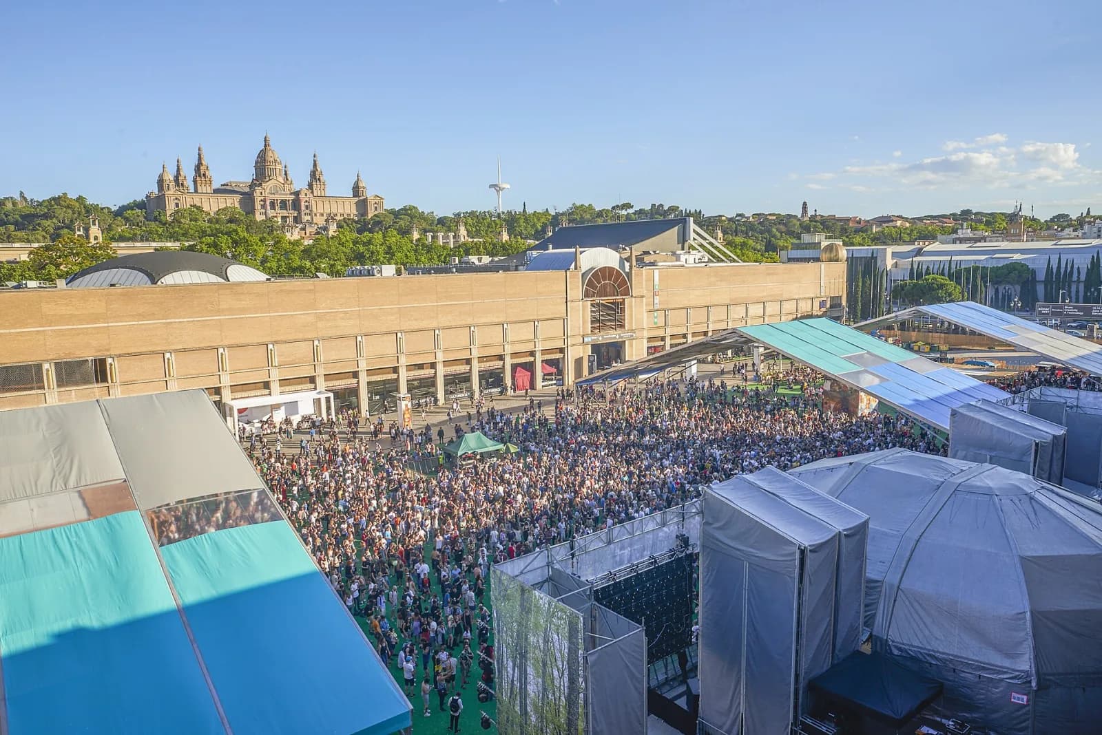 The SonarVillage crowd in daylight at the classic Montjuic site, with the Palau Nacional on the skyline