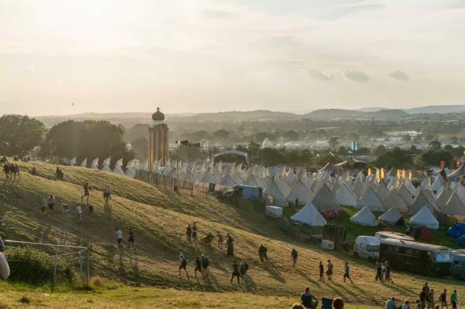 The Park hill and Ribbon Tower at Glastonbury Festival in golden sunlight